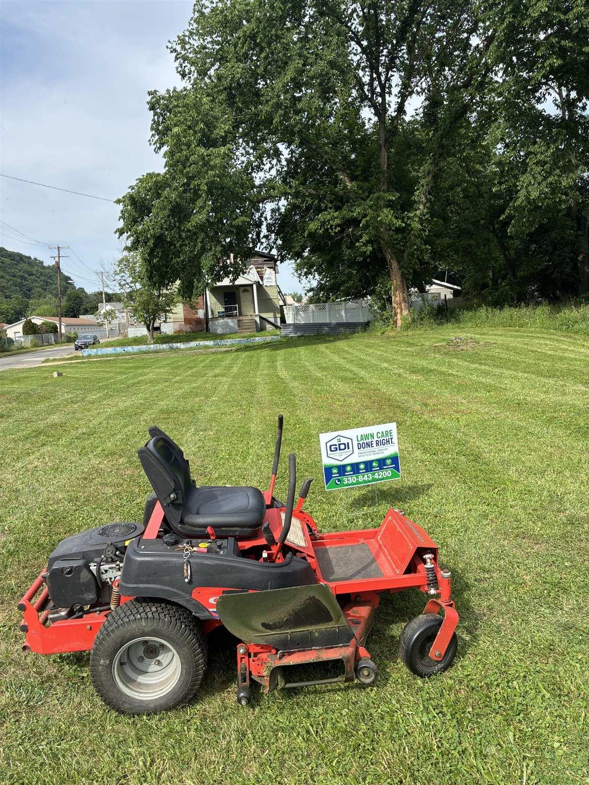 GDI zero-turn mower and yard sign on a freshly cut lawn