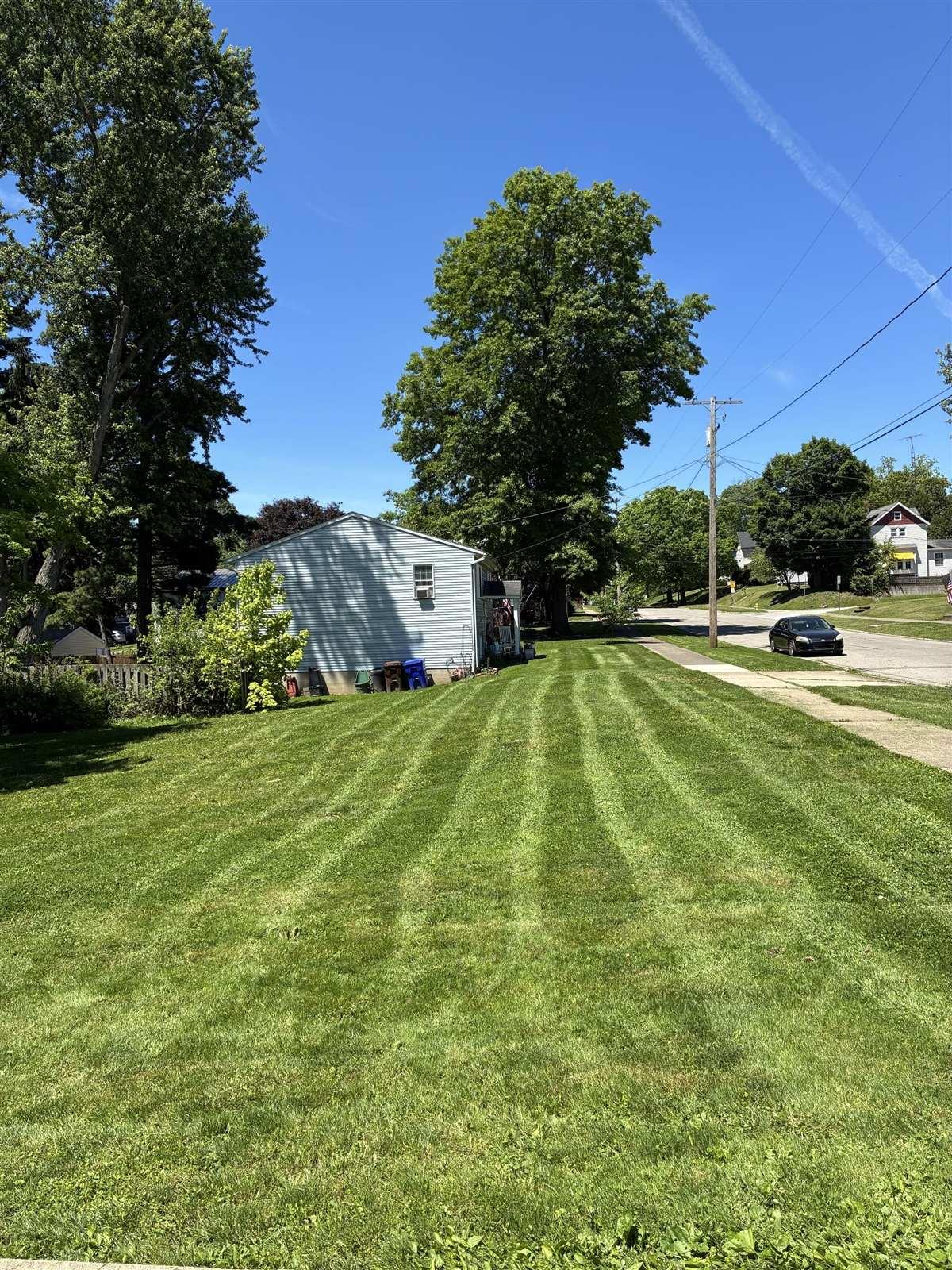 Freshly striped residential front lawn beside a sidewalk