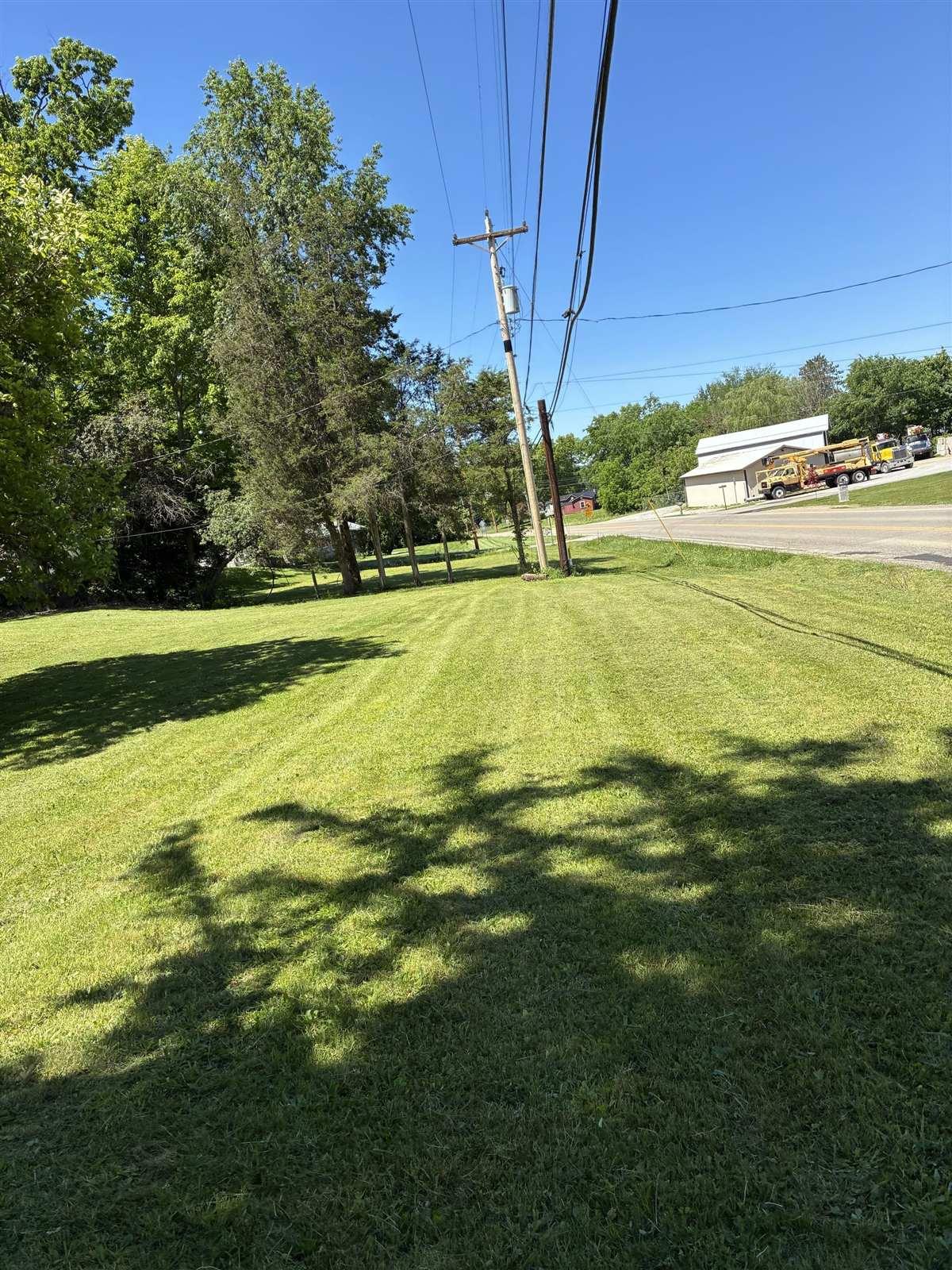 Roadside lawn with fresh mow stripes around utility poles